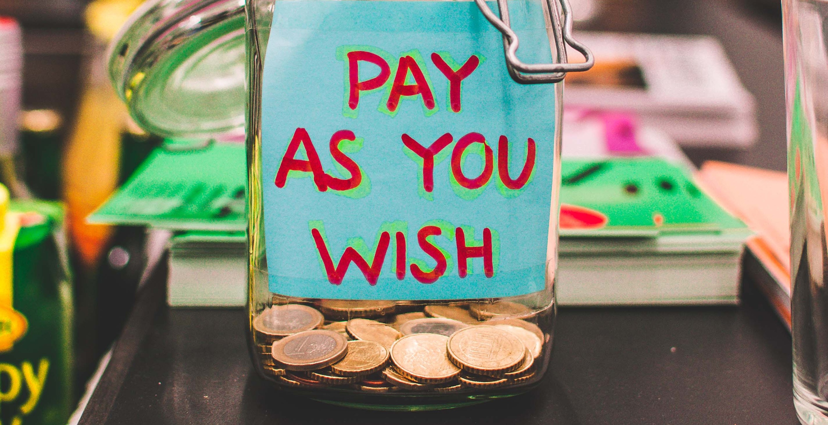 Geldpot met een papiertje waar 'pay as you wish' op staat